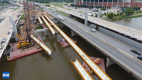 A crane on a barge lifting a steel girder